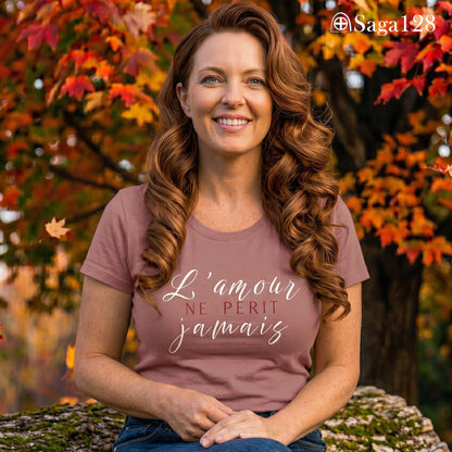 Mulher com camiseta feminina cristã na cor rosa com o texto de 1Coríntios 13.8 em francês, corte feminino | Saga128