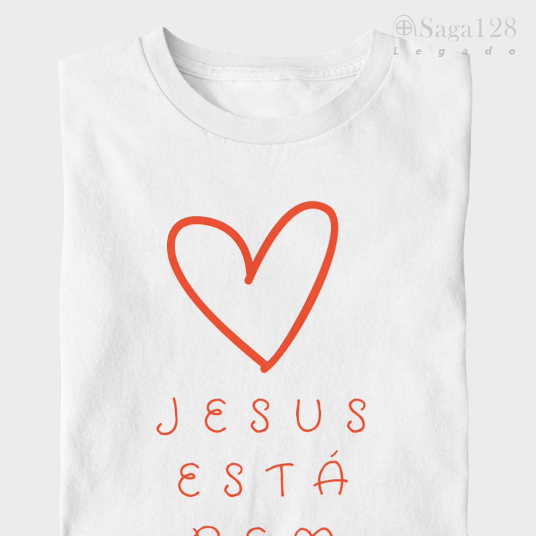 Camiseta cristã infantil feminina branca dobrada com coração e texto 'Jesus está bem aqui'